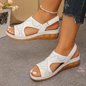 Dettaglio dell'altezza del tacco a zeppa di 5 cm su questi eleganti sandali bianchi
