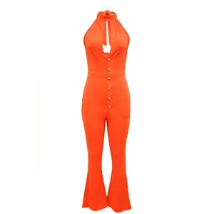 Detail van een levendige oranje jumpsuit met halternek, open rug en gouden knopen.