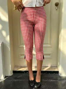 Detail view of stylish red and white gingham cropped pants with side slits at the hem