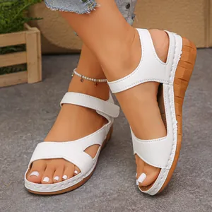 Detailed view of white wedge sandals with velcro straps and comfortable thick soles