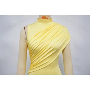 Close-up of yellow ruched mesh sleeveless dress showing elegant drapes on mannequin