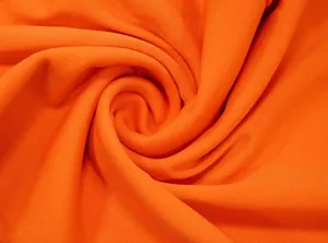 Macro-detail van feloranje ademende gebreide stof met zachte spiraaltextuur