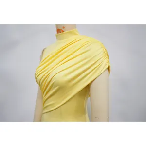 Close-up detail shot showing the elegant ruched and draped texture of the yellow dress.