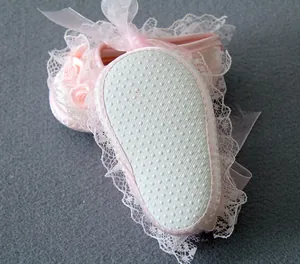 Close-up of pink baby walking shoes featuring lace details and anti-slip soft soles.