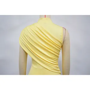 Detailed close-up of yellow pleated mesh bodycon dress featuring elegant back draping