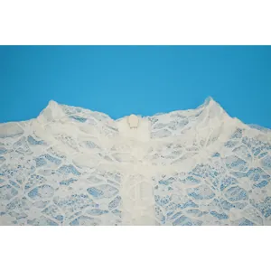 Dettaglio ravvicinato dello scollo in pizzo bianco trasparente con zip invisibile