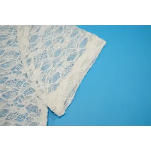 Dettaglio della trama in pizzo bianco sulla manica di una tuta intera estiva alla moda
