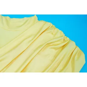 Close-up detail of the vibrant yellow pleated mesh fabric on this elegant mini dress.