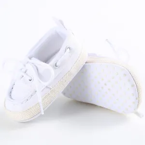 Dettaglio scarpe neonato in tela bianca con suola morbida antiscivolo per 0-1 anni