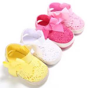Detalle de zapatos de bebé calados de colores con lazo y suela blanda para caminar