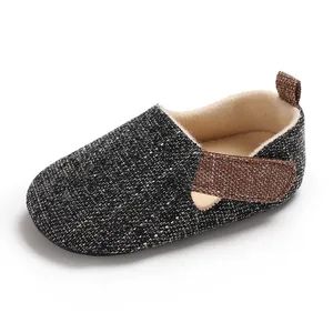 Vista detallada de zapato para bebé en tela de tweed oscuro con correa marrón ajustable