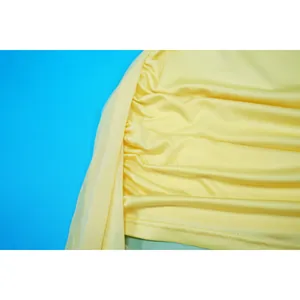Close-up detail of yellow ruched mesh dress showing stitching and pleated texture.
