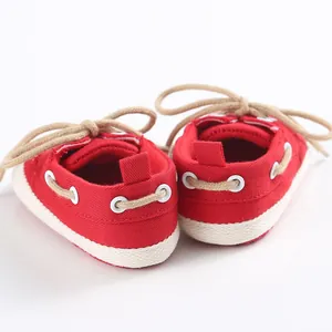 Vista posteriore di scarpe da neonato in tela rossa con suole morbide e lacci