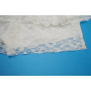 Dettaglio ravvicinato del delicato pizzo floreale bianco per body trasparente