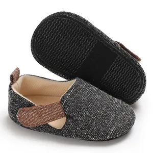 Detalle de zapatos para bebé en tela tejida gris con suela de silicona antideslizante