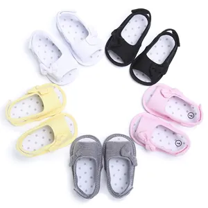 Macro view of multi-colored soft-sole baby sandals with decorative bows