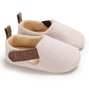 Detalle de zapatos de tela suave para bebé con cierre de velcro en beige