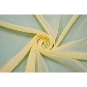 Detail showing the intricate texture of light yellow polyester mesh fabric for dresses