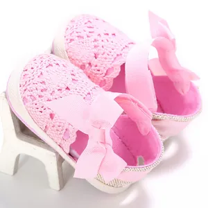 Vista detallada de zapatos de bebé en ganchillo rosa con un lazo de cinta suave y fino