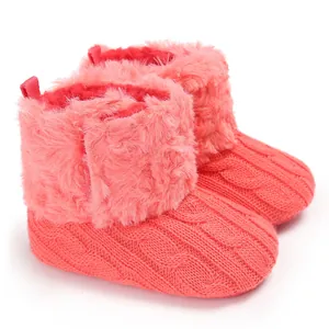 Dettaglio degli stivaletti invernali in maglia rosa per neonati con bordo in ecopelliccia