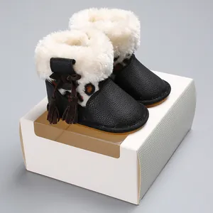 Nahaufnahme von Baby-Winterstiefeln aus schwarzem Leder mit weißem Kunstpelz