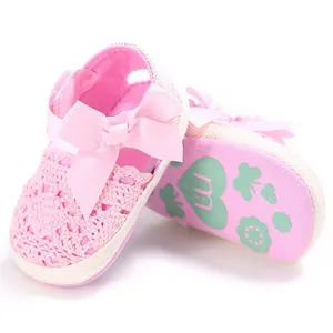 Vue détaillée de chaussures roses ajourées pour bébé avec nœud et semelle souple.