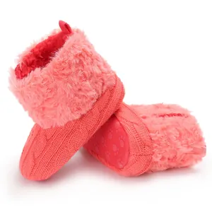 Dettaglio di stivaletti invernali in maglia rosa per neonata con ecopelliccia e suola antiscivolo