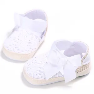Detailed view of white crochet baby walker shoes featuring a large decorative ribbon bow