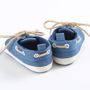 Vista posteriore dettagliata di scarpe in tela blu per neonati con suola morbida e lacci kaki.