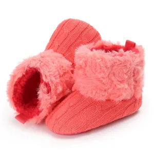 Dettaglio di stivaletti invernali da neonato in maglia rosa con morbida fodera in pelliccia