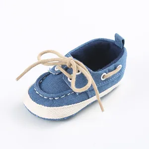 Dettaglio di scarpe in tela blu per neonati con suola bianca morbida e lacci beige