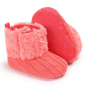 Dettaglio degli stivaletti invernali in maglia rosa per neonati con fodera in ecopelliccia.