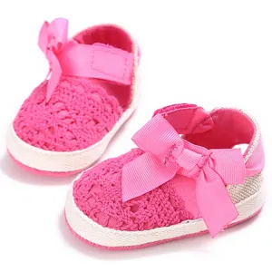 Primer plano de adorables zapatos de ganchillo rosa para bebé con gran lazo de cinta