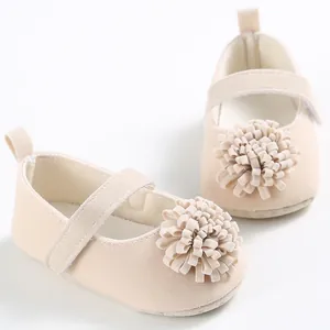 Detalle de zapatos beige para bebé niña con suela blanda y una gran flor decorativa