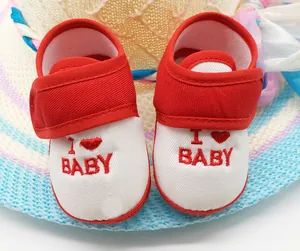 Primer plano de zapatos de bebé rojos y blancos con bordado 'I Love Baby' y suela blanda