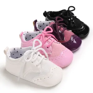 Detailed view of brogue style baby pre-walker shoes in white, pink, purple, and black.