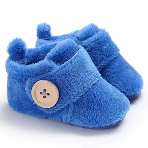 Close-up of soft blue fuzzy baby shoes with a wooden button detail and warm plush lining