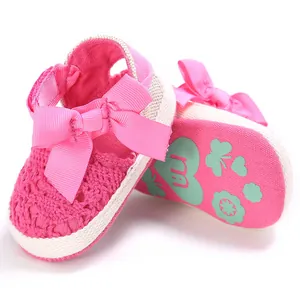 Vue détaillée de chaussures de marche roses ajourées pour bébé avec semelle souple et nœud