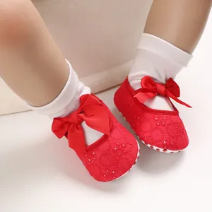 Vue détaillée de chaussures de princesse pour bébé en dentelle rouge avec des nœuds
