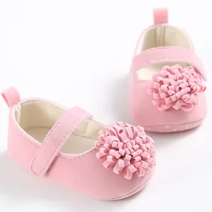 Primer plano de zapatos de princesa para bebé en rosa con suela blanda y flor de tela decorativa