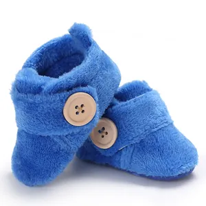 Detail shot of soft blue plush baby booties featuring decorative wooden buttons