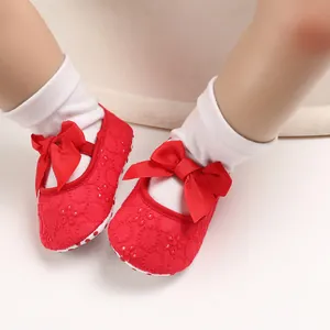 Vue détaillée de chaussures de princesse rouges pour bébé avec nœud et broderie