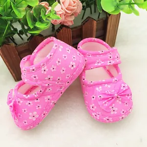 Detailed view of pink floral baby walker shoes with a decorative bow and soft sole.