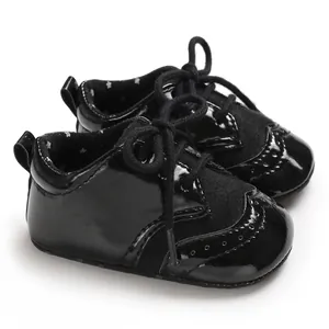 Close-up of black baby oxford shoes with elegant brogue wingtip details