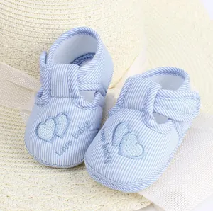 Primer plano de zapatos de bebé a rayas azules con suela blanda y bordado de corazón