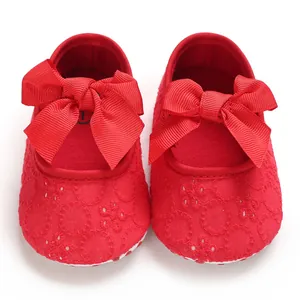 Vue détaillée de chaussures de marche rouges pour bébé avec de grands nœuds décoratifs