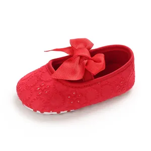 Vue détaillée de la chaussure rouge pour bébé avec broderie et un grand nœud élégant