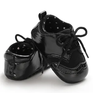 Detail shot of black patent leather infant walker shoes with wingtip perforations