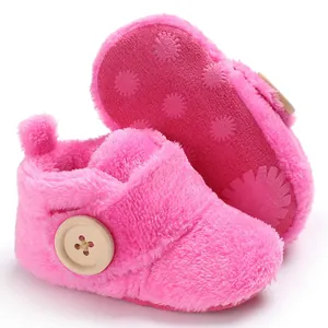 Close-up of pink fuzzy baby shoes with soft anti-slip sole and decorative button