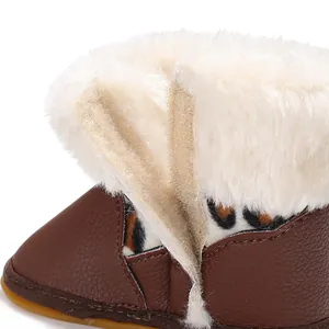 Detailaufnahme von Baby-Lernlaufstiefeln mit Kunstfellmanschette und Klettverschluss.